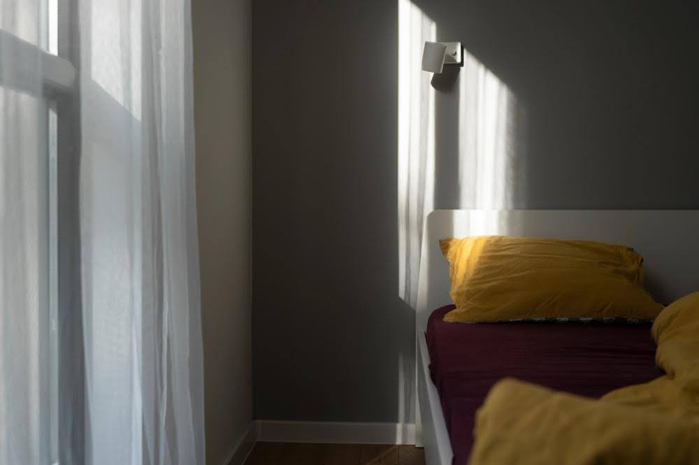 A softly-lit bedroom, shaded with the best solar screen fabrics.