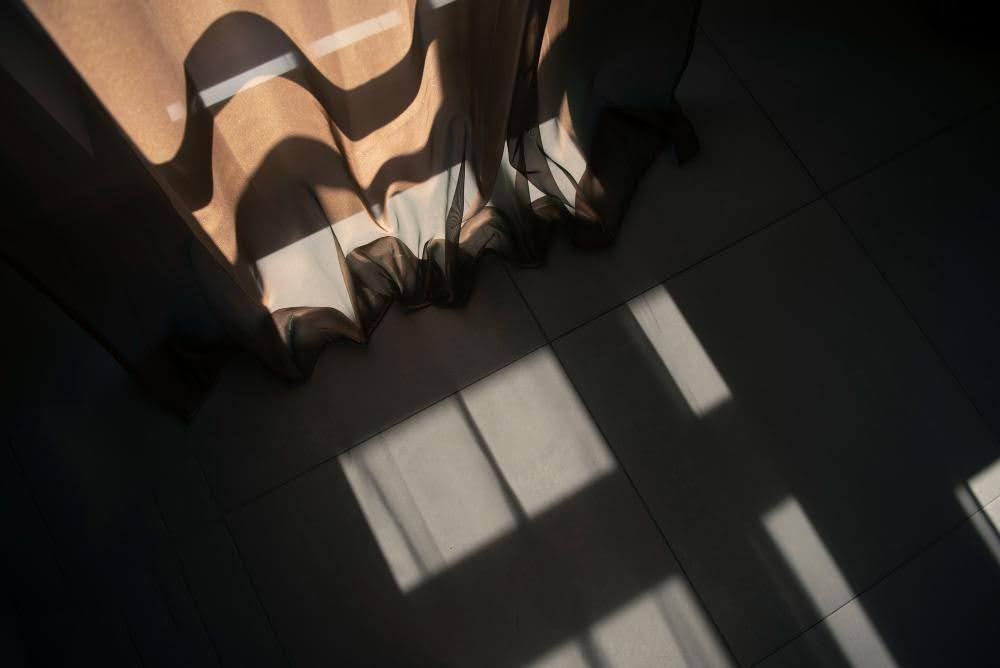 A dimly lit room with solar shades helping reduce heat.