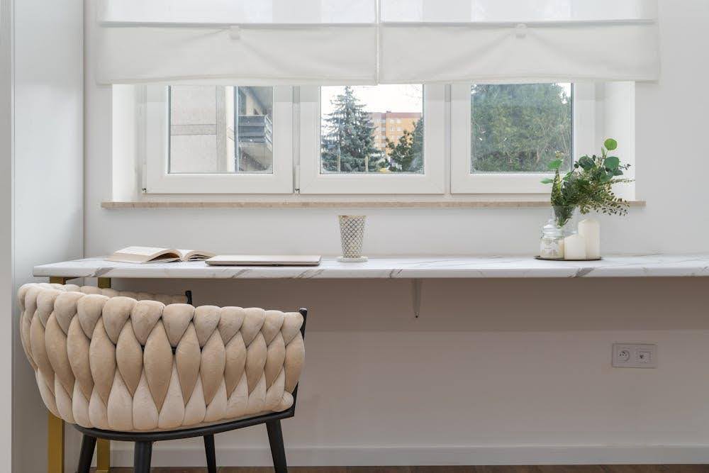A bright room with a triple-pane window partially covered by blackout shades.
