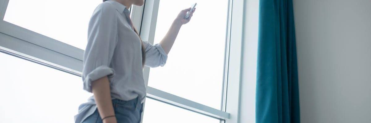 A woman showing how to charge motorized shades.