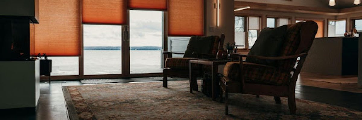 cozy living room with wooden armchairs and motorized shades filtering natural light.